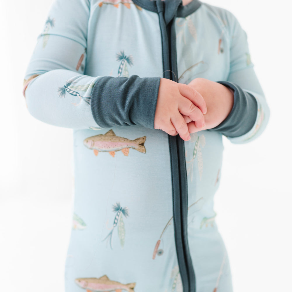 
                      
                        Child wearing a light blue onesie with animal prints on a white background
                      
                    