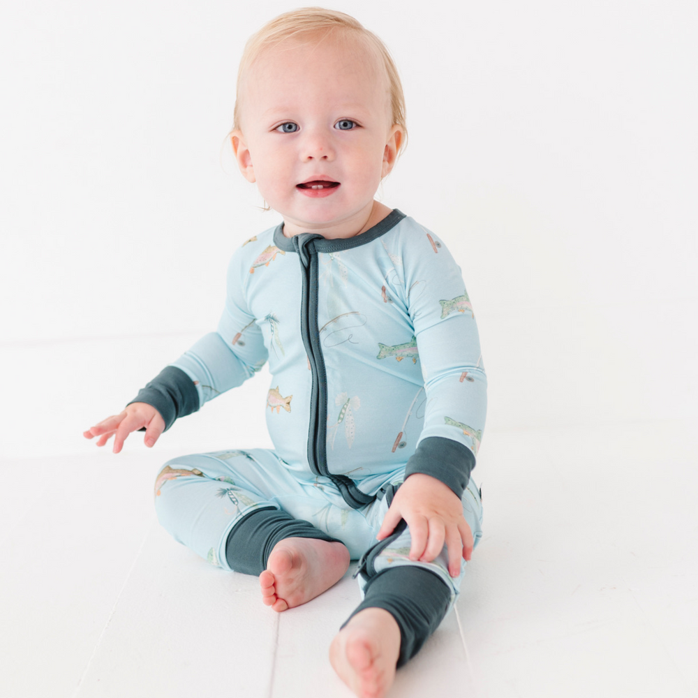 Baby wearing a light blue onesie with dark gray accents on a white background
