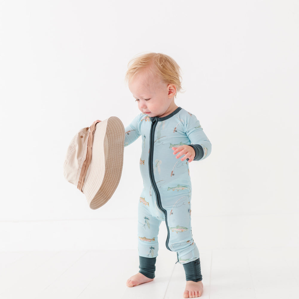 
                      
                        Baby in a blue onesie with a hat on a white background
                      
                    