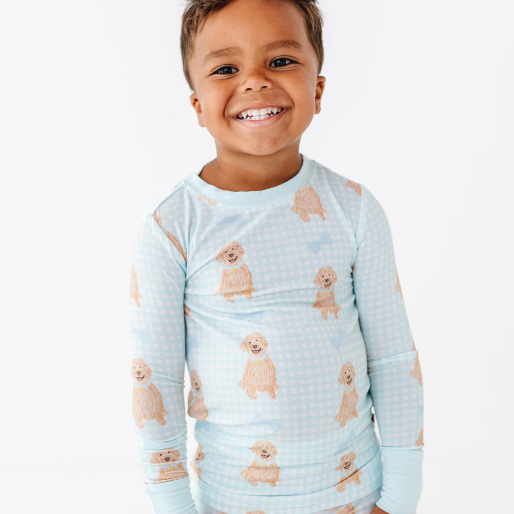 
                      
                        Child wearing a light blue pajama set with dog prints on a white background
                      
                    