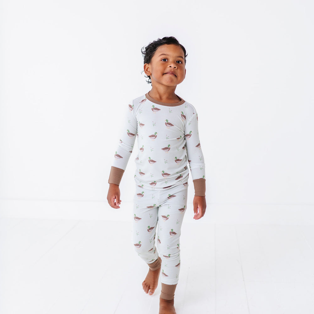 
                      
                        Child wearing a white onesie with bird pattern on a white background
                      
                    
