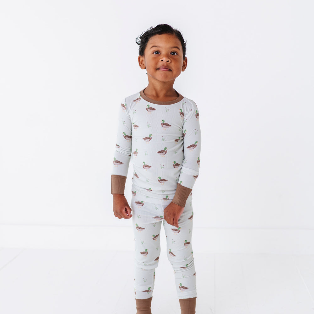 
                      
                        Child wearing a white long-sleeve pajama set with small prints on a white background
                      
                    