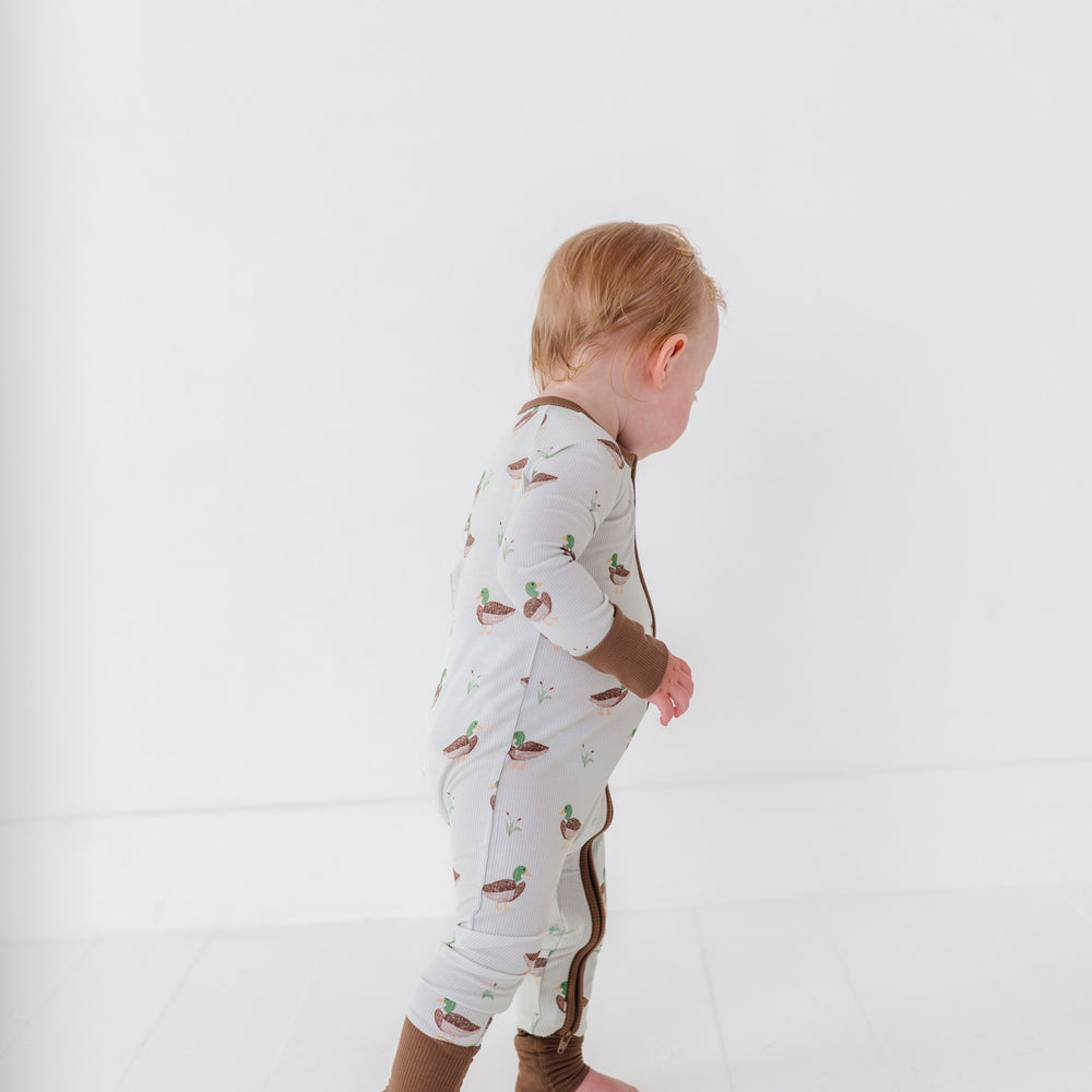 
                      
                        Child wearing a patterned onesie on a white background
                      
                    