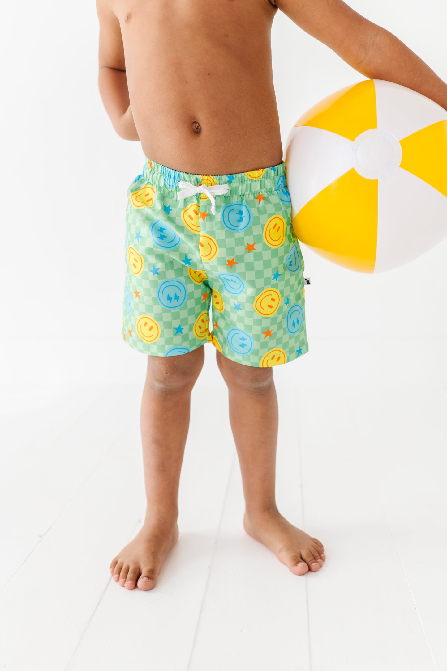 Boy in Neon Smiley Swim Trunks