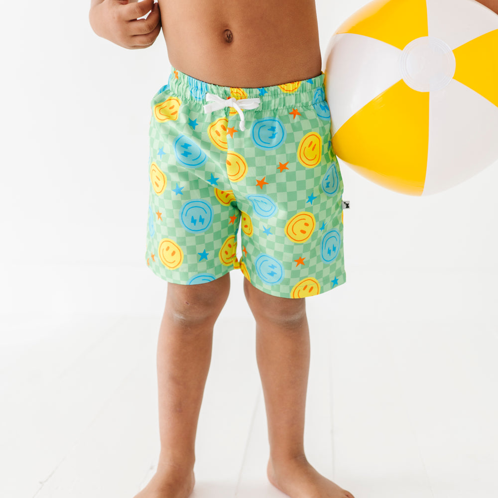 
                      
                        Boy in Neon Smiley Swim Trunks
                      
                    