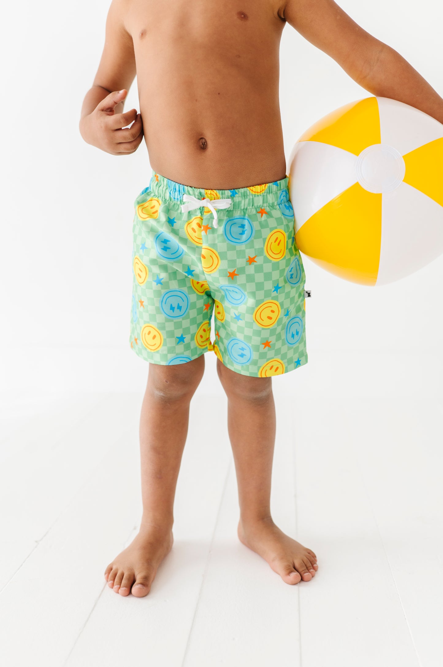 Boy in Neon Smiley Swim Trunks