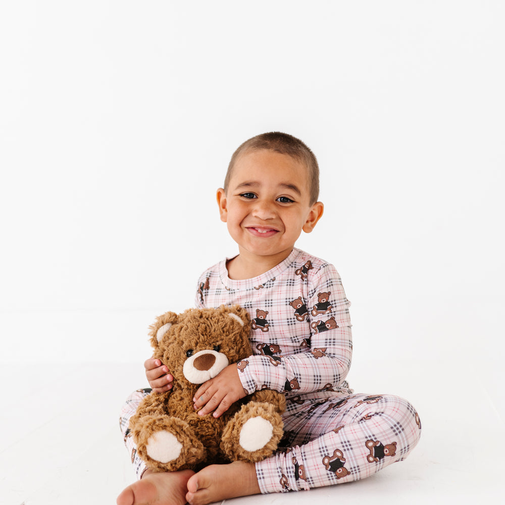 
                      
                        Child holding a teddy bear on a white background
                      
                    
