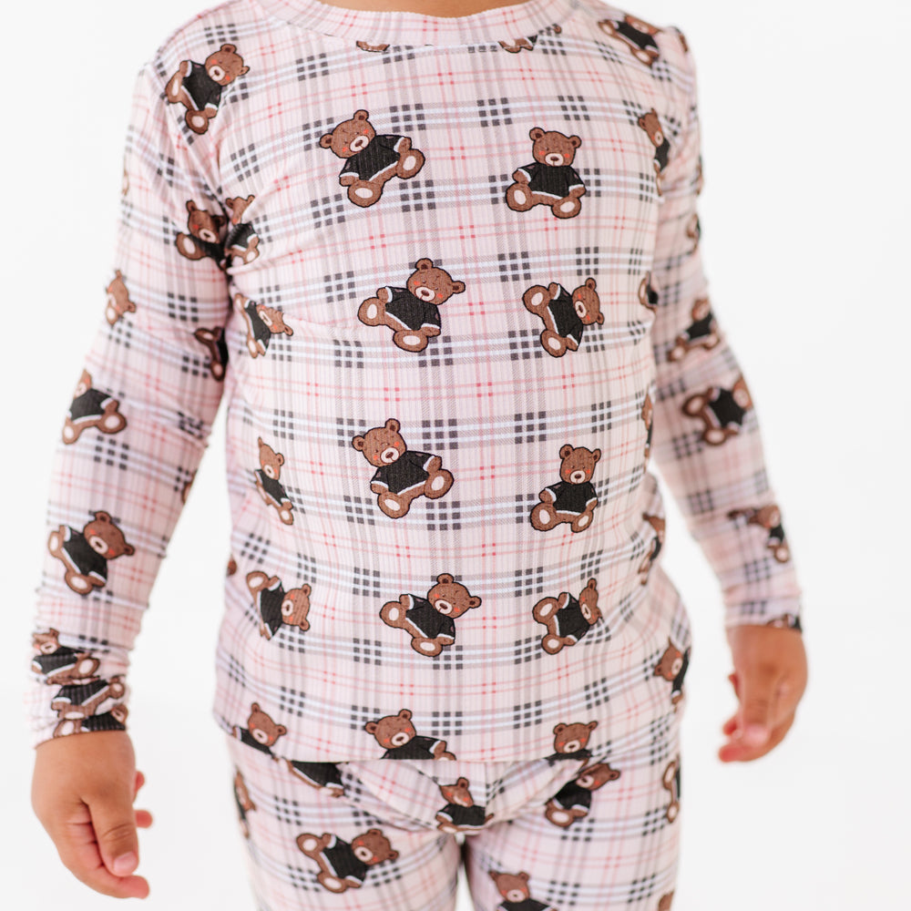Child wearing pajamas with teddy bear pattern on a white background