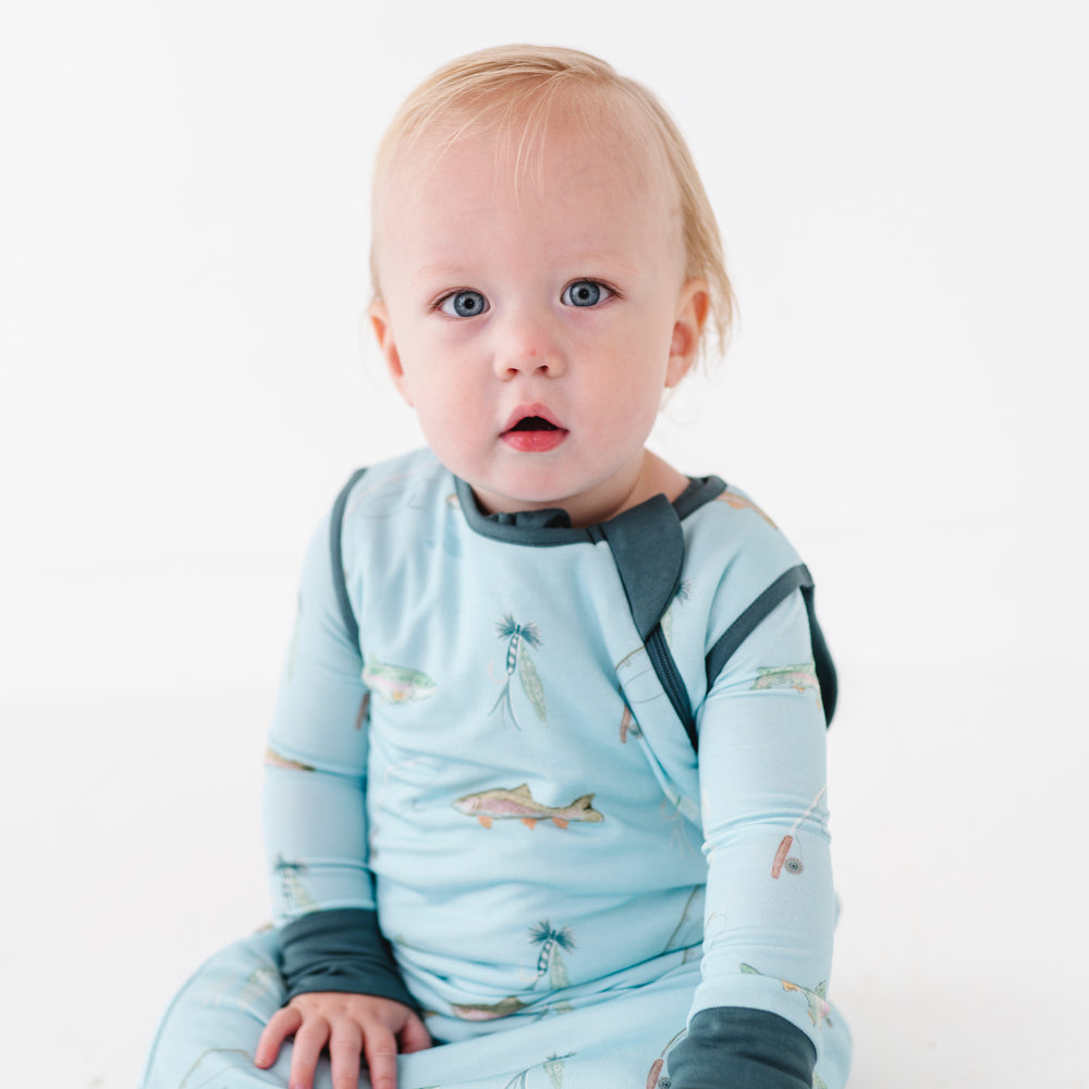 
                      
                        Baby wrapped in a blue sleep sack on a white background
                      
                    