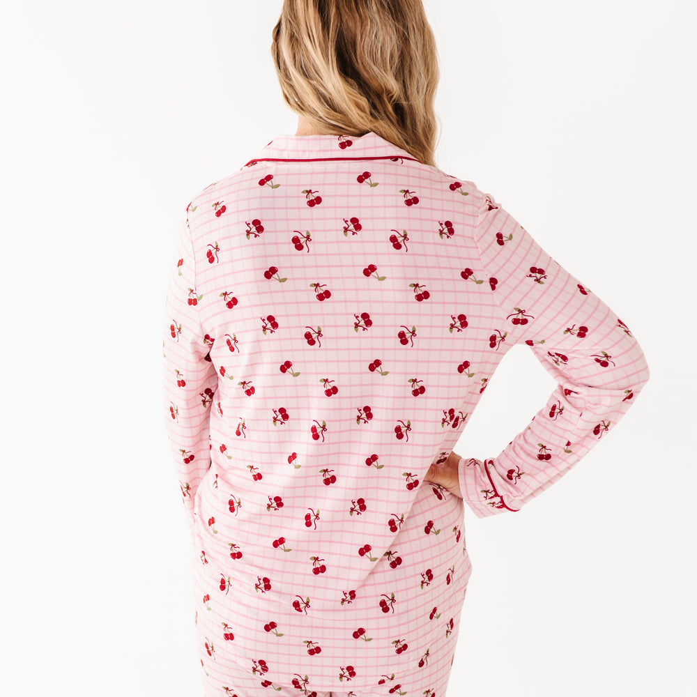 
                      
                        Person wearing pink pajamas with red cherry pattern on a white background
                      
                    