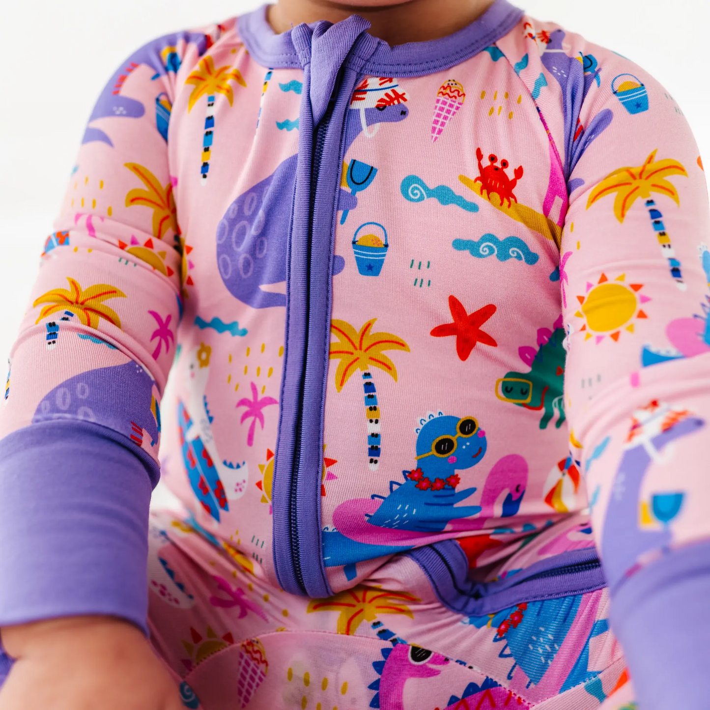 Baby Girl in dinosaur pajamas by Kiki and Lulu