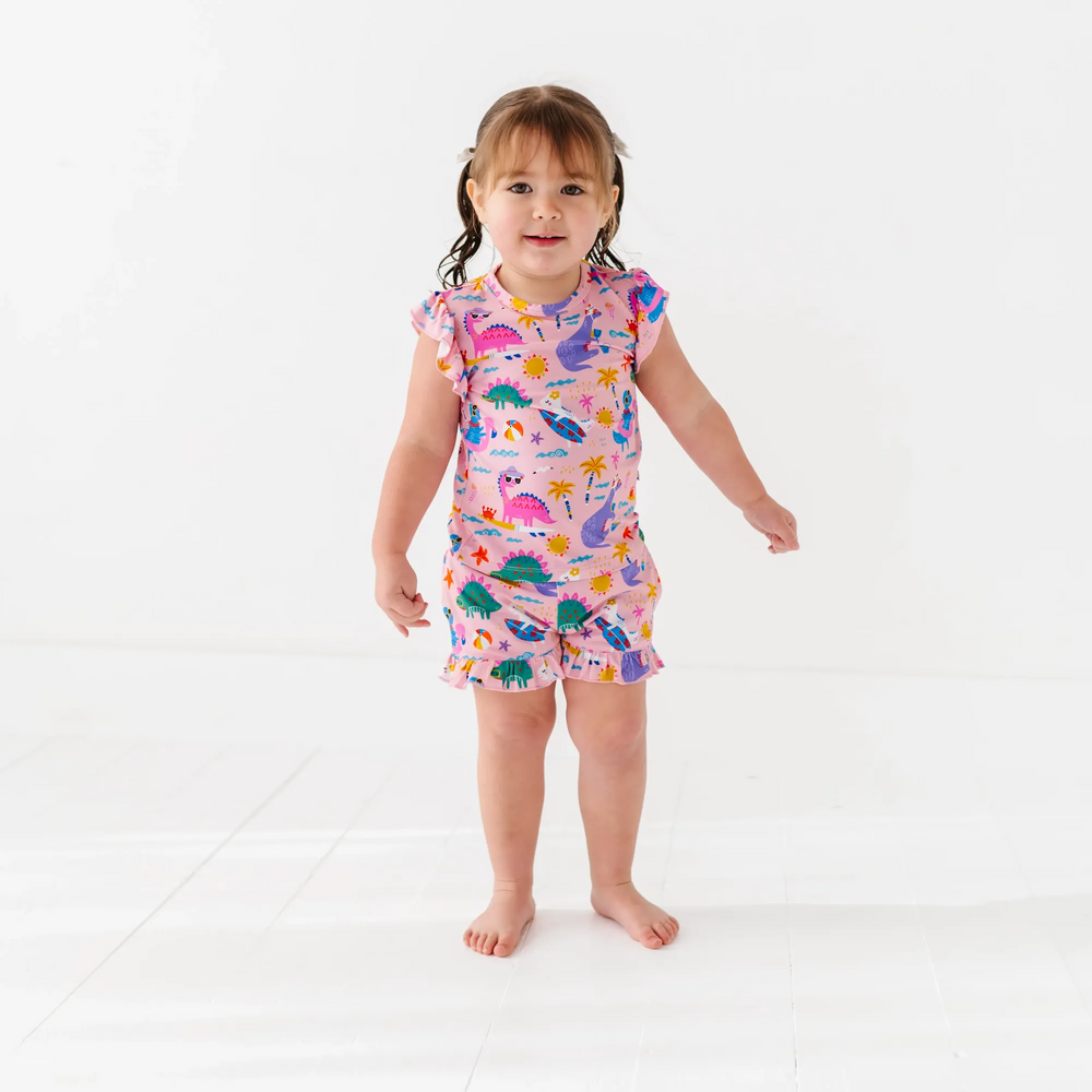 Girl in short pajama dinosaur set by Kiki and Lulu