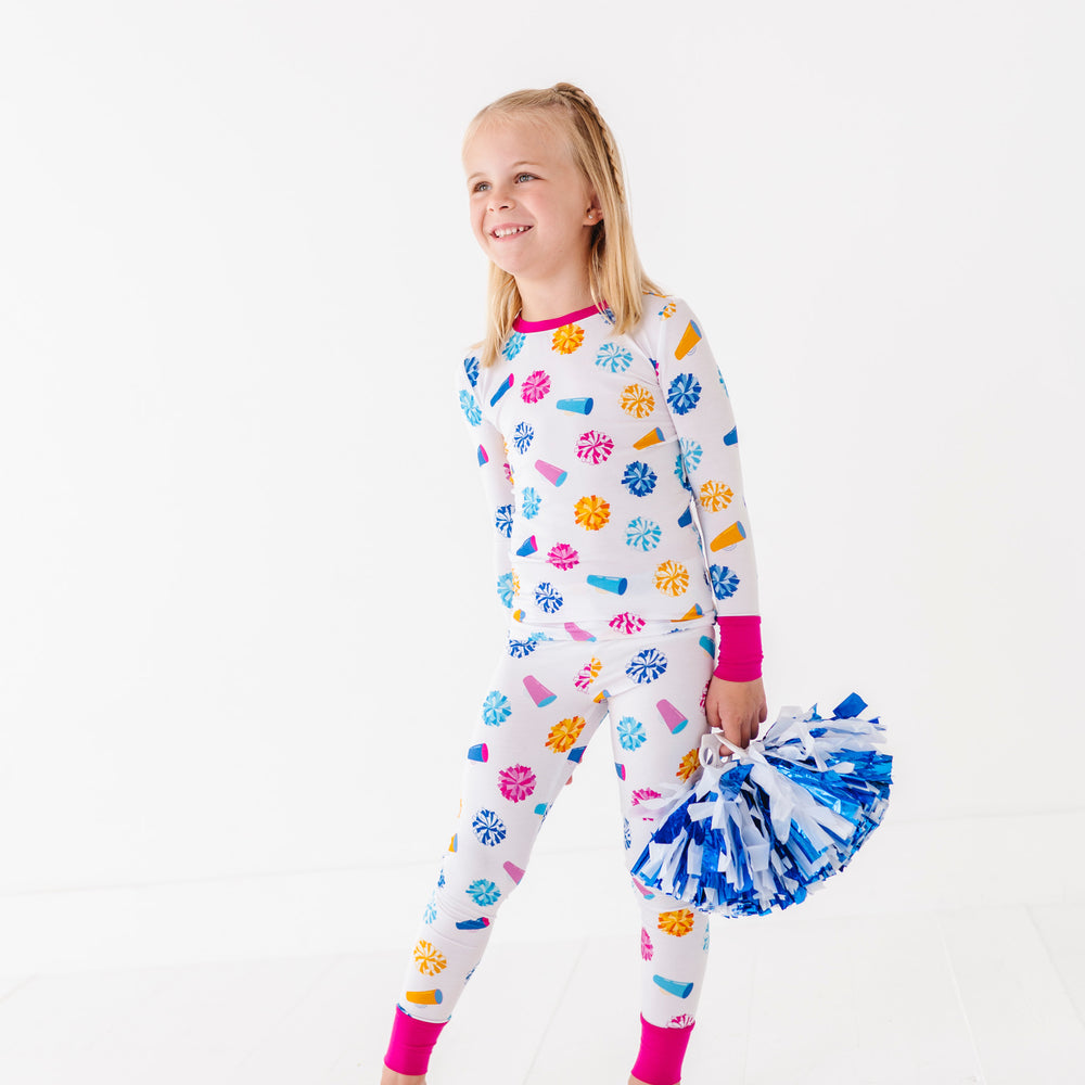 
                      
                        Child wearing colorful pajamas with paw prints and a pom-pom on a white background
                      
                    
