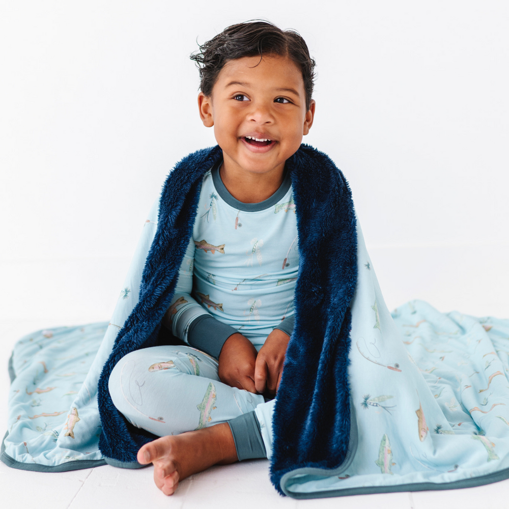 Child wrapped in a blue blanket with a white background