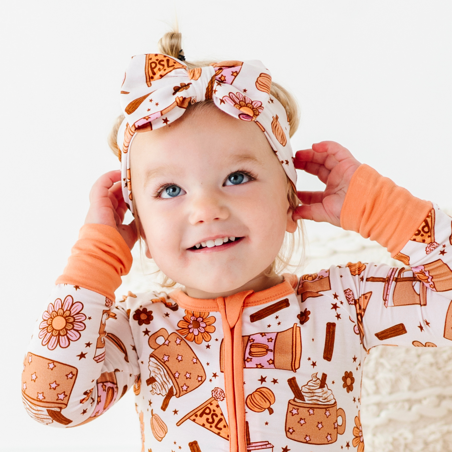 Baby wearing pumpkin spice latte bow